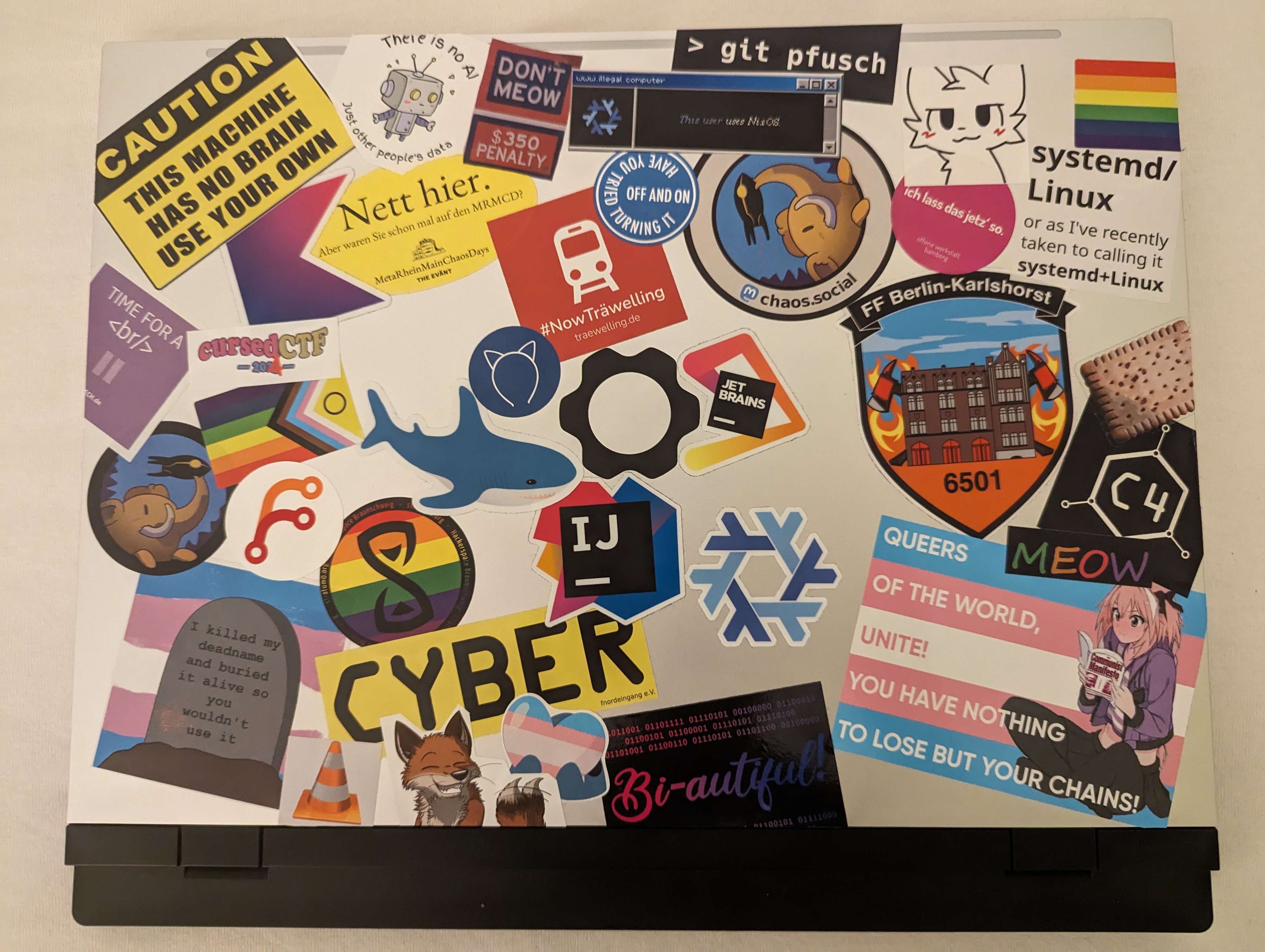 A picture of a laptop with a lots of stickers